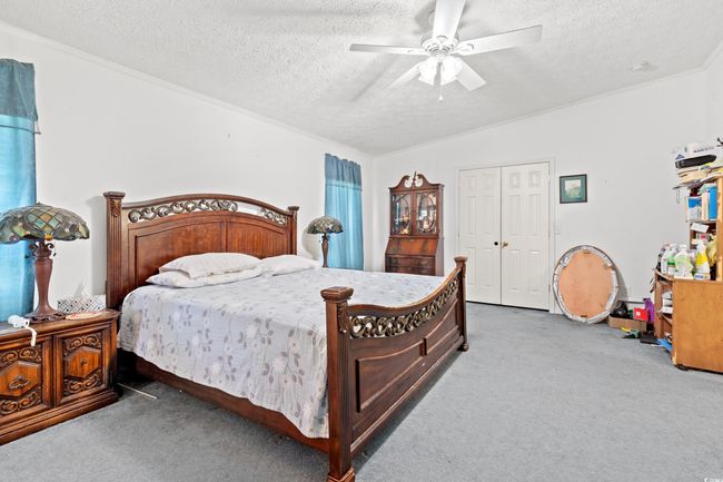 Carpeted bedroom with a textured ceiling and ceiling fan | Image 10
