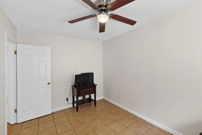 Spare room featuring a ceiling fan, light tile patterned floors, and a textured ceiling | Image 24