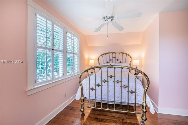 Bedroom featuring dark wood-type flooring, lofted ceiling, and ceiling fan | Image 35