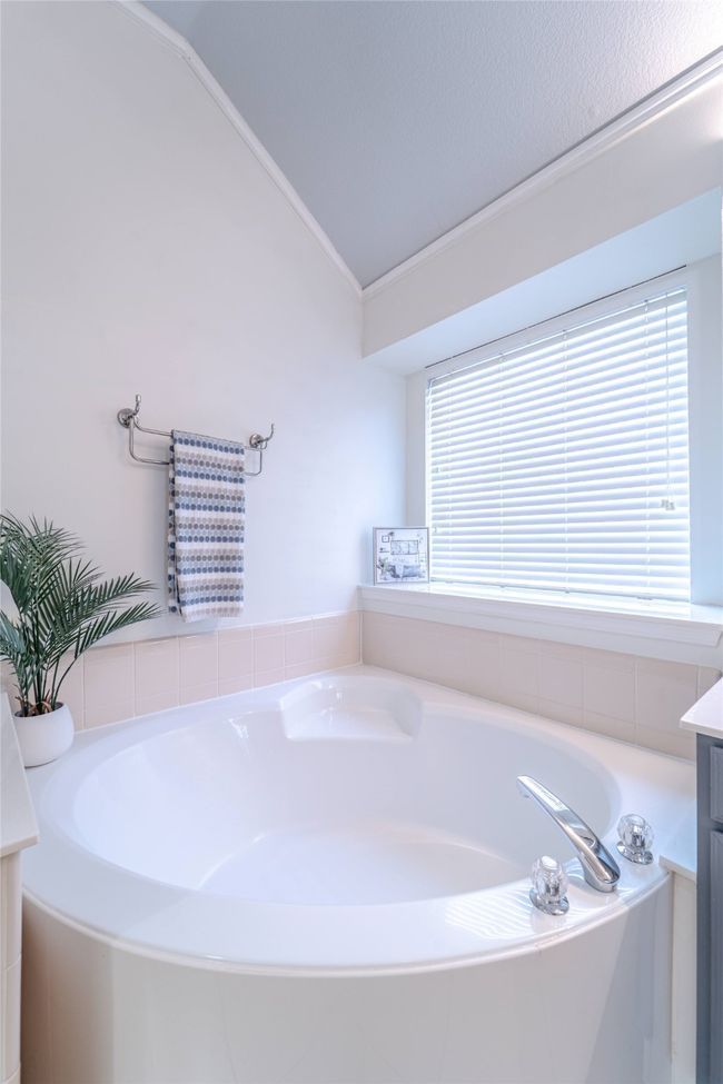 Full bathroom featuring lofted ceiling, vanity, and a garden tub | Image 28