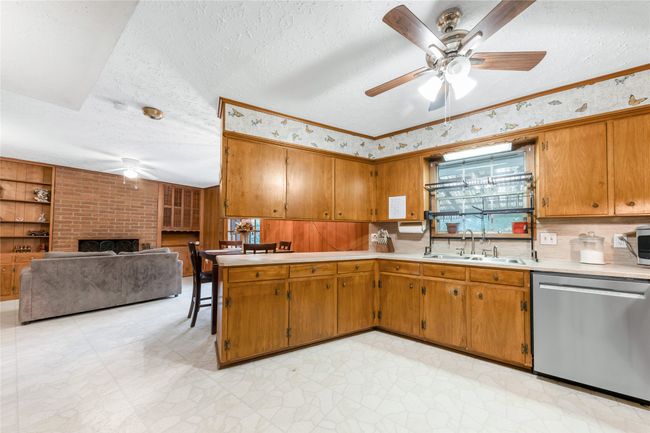 Kitchen view into dining area showing fireplace and built-in shelving | Image 9