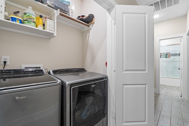 Laundry room featuring washer and clothes dryer and wood finish floors | Image 33