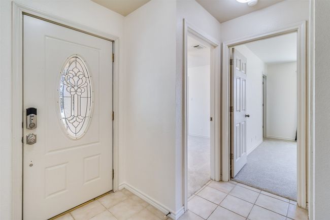 Entrance foyer with light tile patterned flooring, visible vents, light colored carpet, and baseboards | Image 5