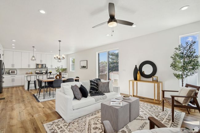 Living area featuring recessed lighting, light wood-type flooring, and ceiling fan with notable chandelier | Image 6