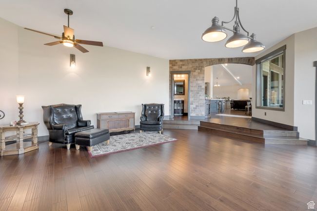 Sitting room featuring ceiling fan, arched walkways, wood finished floors, lofted ceiling, and baseboards | Image 18