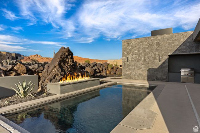 Pool featuring exterior kitchen, a patio, and area for grilling | Image 49
