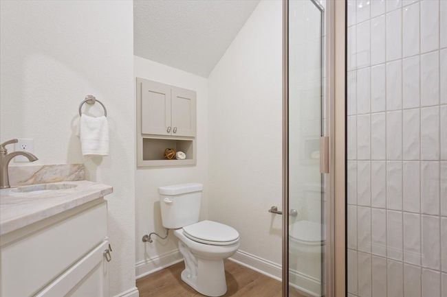 Bathroom with wood finished floors, vanity, a stall shower, and lofted ceiling | Image 31