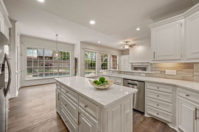 Kitchen tasteful backsplash, appliances with stainless steel finishes, white cabinets | Image 16
