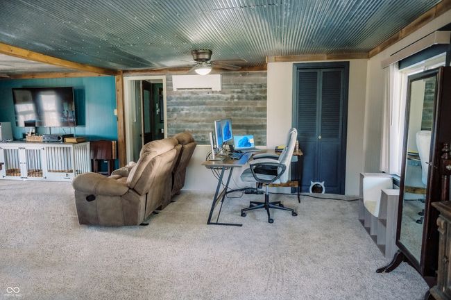 living area with a wall mounted air conditioner, carpet, and ceiling fan | Image 33