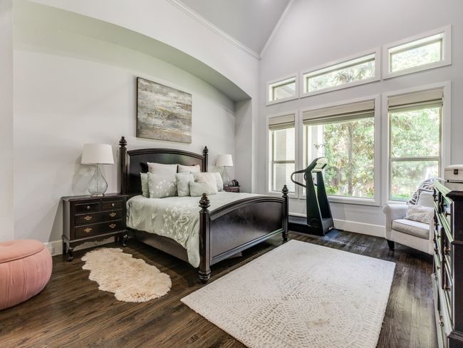 Bedroom with crown molding, high vaulted ceiling, baseboards, and dark wood-style floors | Image 11