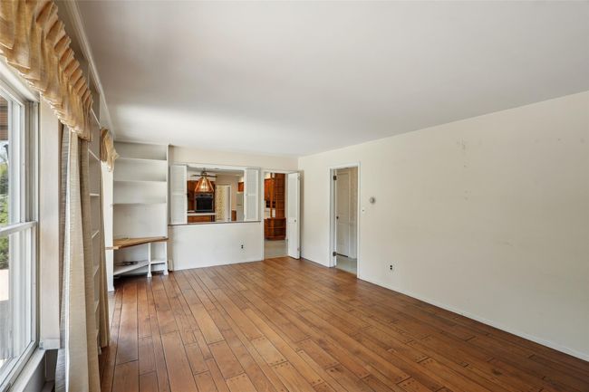 Unfurnished living room with baseboards and hardwood / wood-style flooring | Image 16