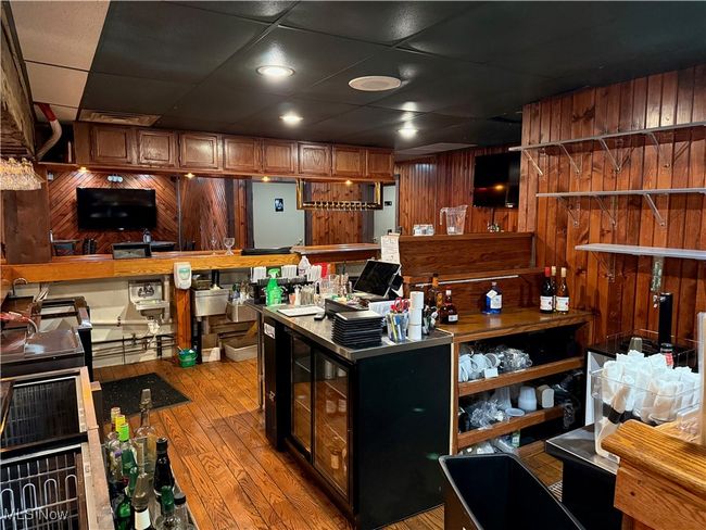 Kitchen with hardwood / wood-style floors, wooden walls, and a drop ceiling | Image 23