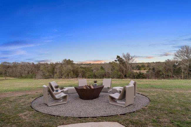 The staged firepit is perfect for making s'mores with family, or enjoying a beverage in the evening. A pool house, guest house or other outbuilding have many potential locations without obstructing this beautiful view! | Image 47
