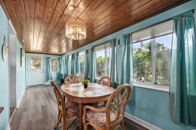 Sunroom / solarium with wood ceiling, a chandelier, wood finished floors, and baseboards | Image 31