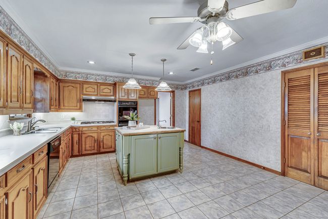 Spacious kitchen for cooking and entertaining! 5-burner gas stovetop, double oven and island with a second sink. | Image 8