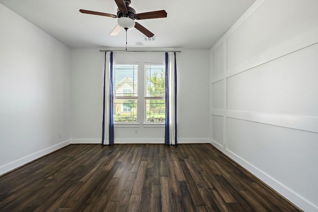 Unfurnished room featuring dark wood-style flooring, ceiling fan, visible vents, and baseboards | Image 19