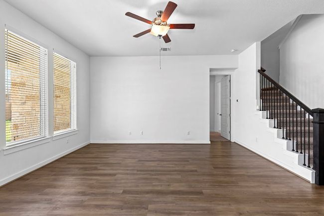 Unfurnished living room featuring stairway, ceiling fan, dark wood-style floors, and baseboards | Image 20