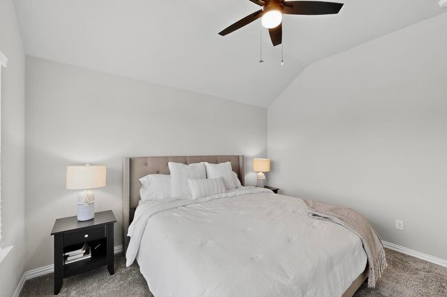 Carpeted bedroom with vaulted ceiling and a ceiling fan | Image 22
