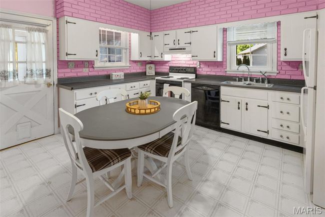 Kitchen featuring white appliances, light floors, dark countertops, and white cabinetry | Image 19