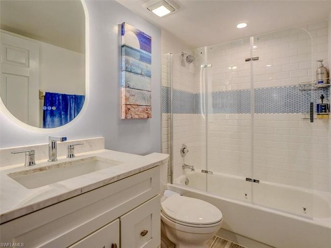 GUEST BATH W/MARBLE-TOPPED VANITY, ANTI-FOG BACKLIT MIRROR. COMBO TUB/SHOWER W/GLASS DOORS AND FULL-HEIGHT TILED SHOWER WALLS. | Image 31