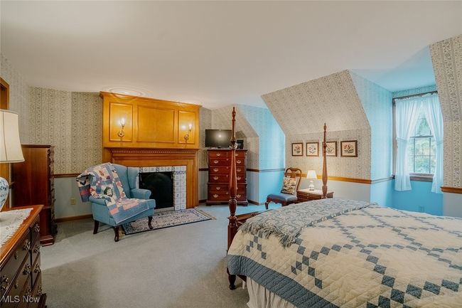 Carpeted master bedroom with wallpapered walls and a fireplace | Image 19