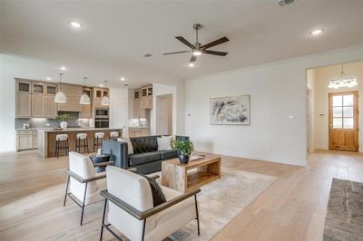 Living room featuring light hardwood / wood-style floors, crown molding, 10 ft ceilings, 8 ft doors, ceiling fan | Image 3