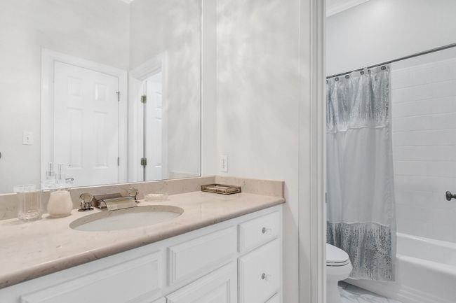 Full bathroom featuring vanity, shower / bath combination with curtain, and marble finish floors | Image 28