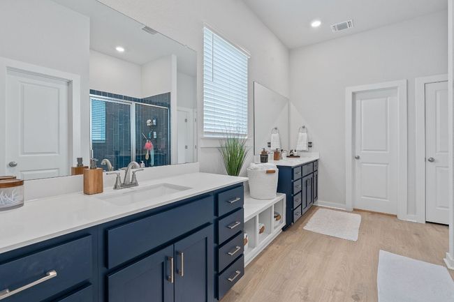 Full bathroom with a shower stall, wood finished floors, a sink, and visible vents | Image 17