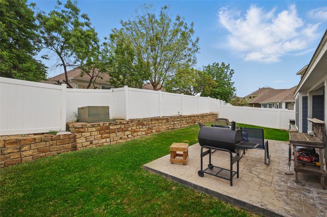 Fenced backyard with a patio area | Image 36