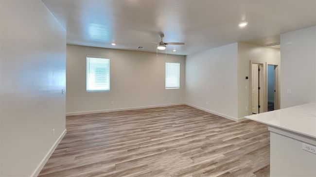 Unfurnished living room with visible vents, a ceiling fan, light wood-style flooring, and baseboards | Image 5