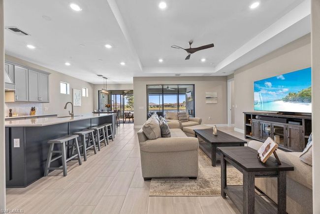 Living room with visible vents, baseboards, ceiling fan, recessed lighting, and a raised ceiling | Image 33