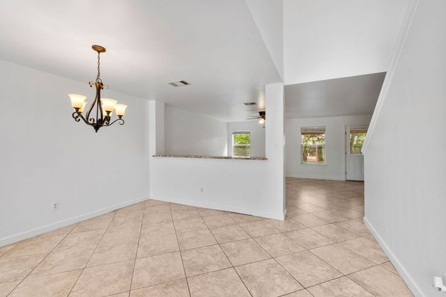 Spare room featuring light tile patterned floors, a ceiling fan, and baseboards | Image 6