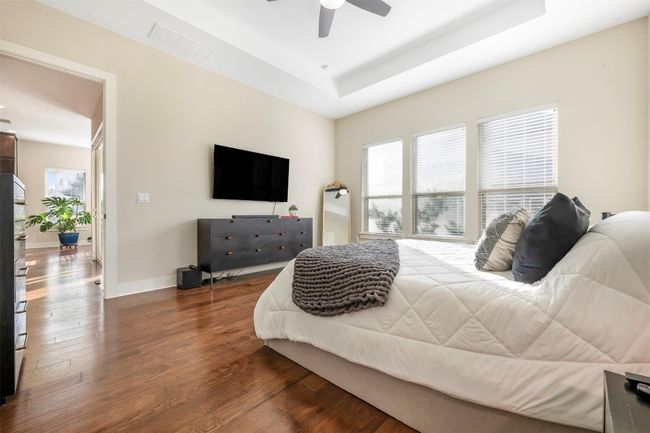 Bedroom with multiple windows, a raised ceiling, and dark wood-type flooring | Image 19