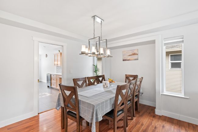 Dining room with wood finished floors, baseboards, and a chandelier | Image 5