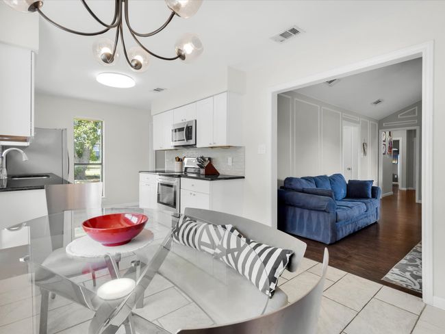 Dining room featuring lofted ceiling and a chandelier | Image 9