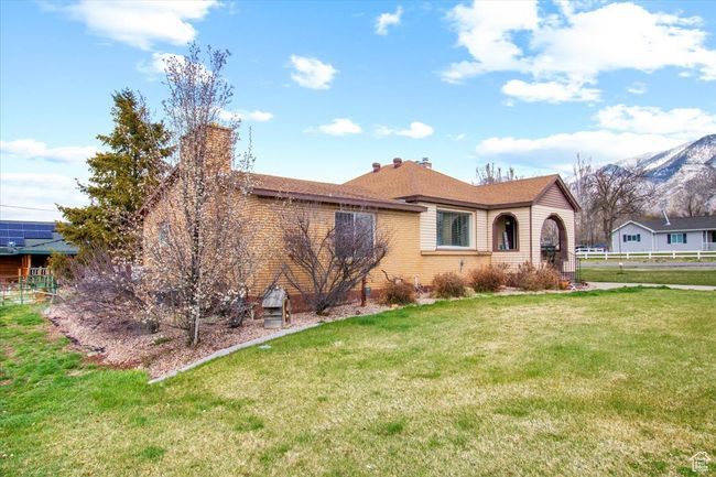 Single story home featuring brick siding, a front yard, and a chimney | Image 13