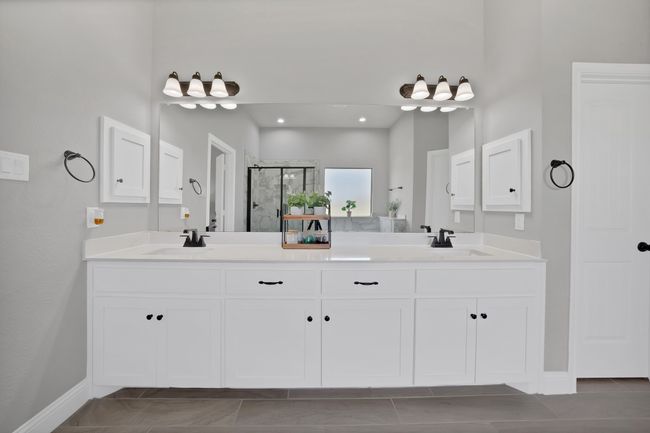 Bathroom with a stall shower, double vanity, and baseboards | Image 25