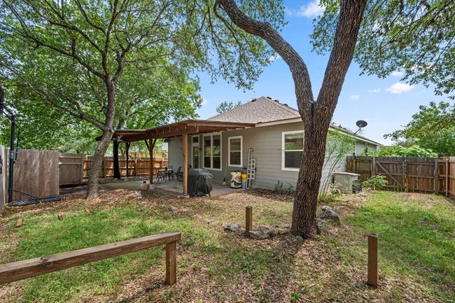 Rear view of house featuring a patio, a shingled roof, and a gate | Image 27