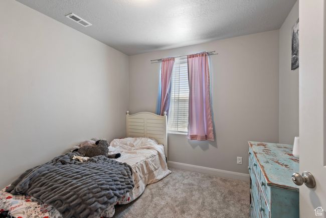 Bedroom with carpet, a textured ceiling, visible vents, and baseboards | Image 17