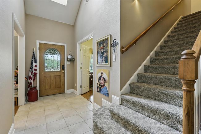 Foyer entrance featuring stairs, light tile patterned floors, and a towering ceiling | Image 8