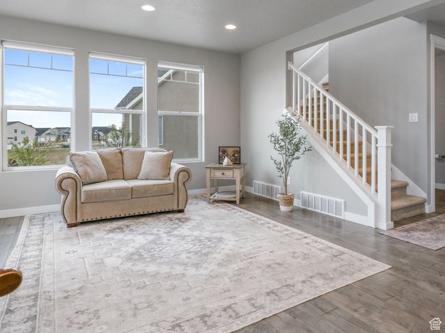 Living area featuring wood finished floors, visible vents, recessed lighting, and stairs | Image 11