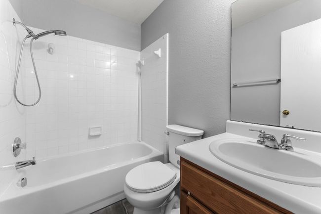 Guest Bathroom featuring vanity, shower combination, and a textured wall | Image 19