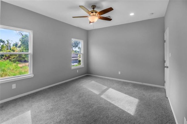 The primary bedroom has plenty of natural light, a walk-in closet, and an adjoining bathroom. | Image 9
