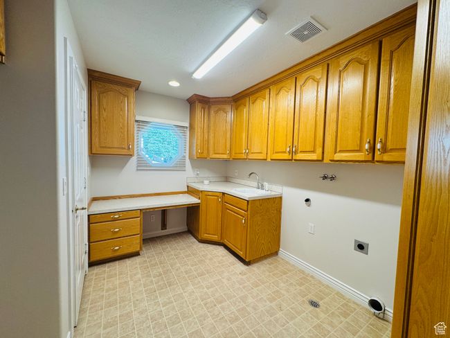 Laundry area with cabinet space, hookup for an electric dryer, craft desk, built-in ironing board, space for additional refrigerator or freezer. | Image 19