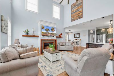 Living room with a towering ceiling and light hardwood / wood-style floors | Image 3