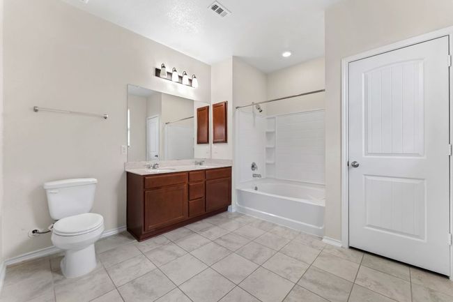 Primary Bathroom double vanity, tile patterned floors, and shower / bathtub combination | Image 17