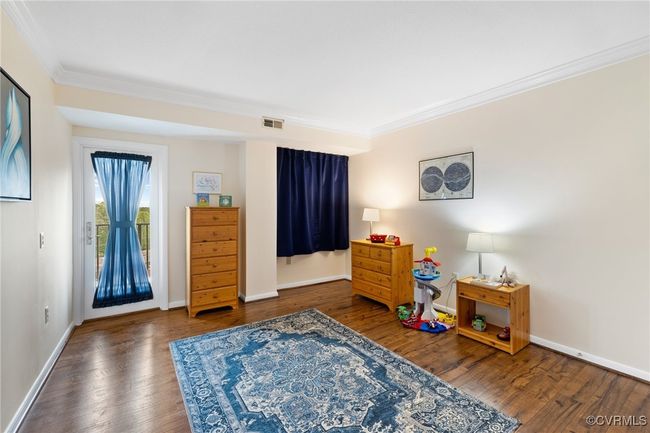 Bedroom featuring crown molding, visible vents, access to outside, and wood finished floors | Image 14