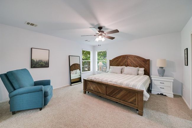 Bedroom featuring light colored carpet and a ceiling fan | Image 10