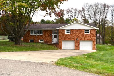 View of front of property featuring a garage and a front lawn | Image 1