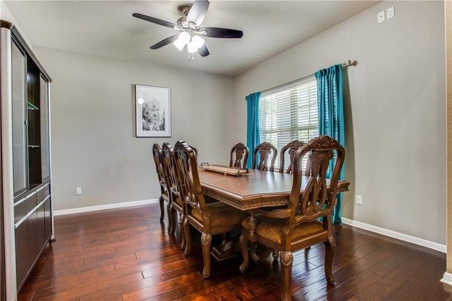 Dining space with a ceiling fan and dark wood-type flooring | Image 4